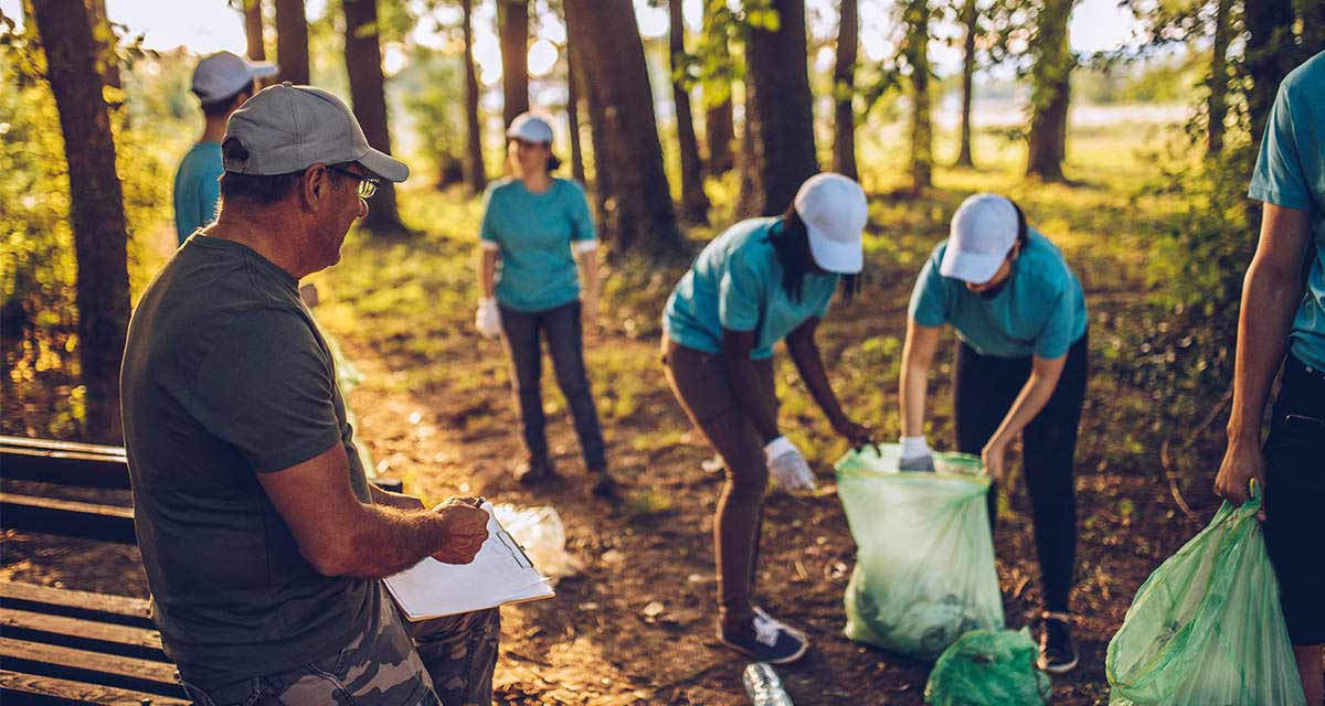 Dei volontari raccolgono rifiuti in un bosco