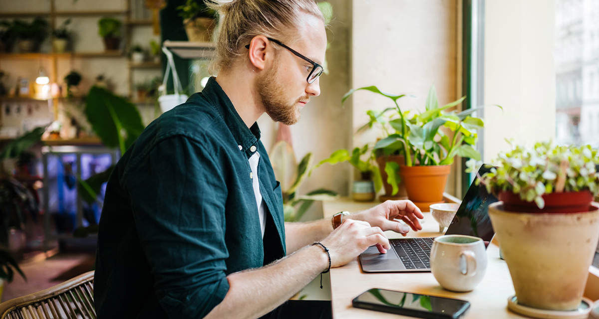 Un giovane uomo al computer in un soggiorno: l’Ecobonus si gestisce da casa