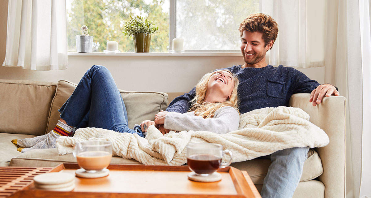 Coppia rilassata in salotto riscaldato con pannelli a infrarossi a onda lunga