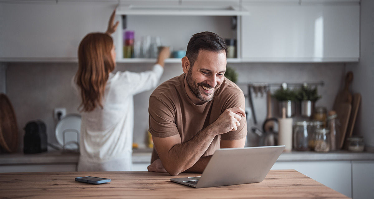 Un giovane uomo controlla il tablet sul tavolo da cucina per scegliere la migliore offerta gas 