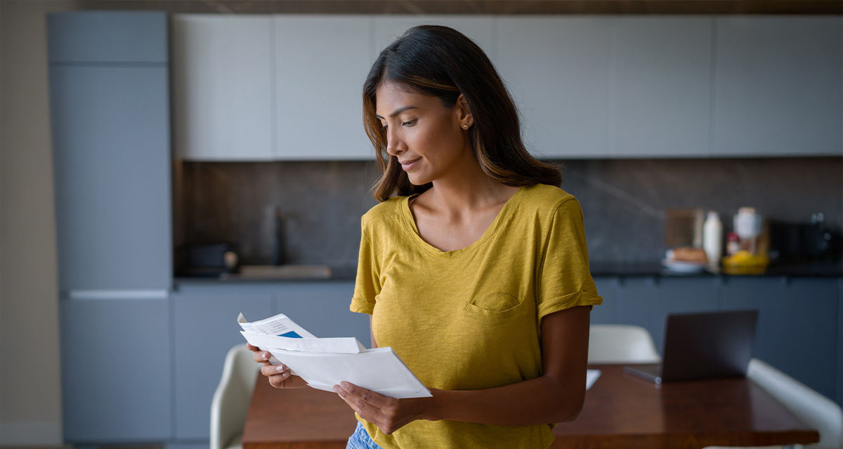 Una giovane donna controlla le bollette: CTE e scheda sintetica sono documenti da fornire ai clienti insieme all’offerta
